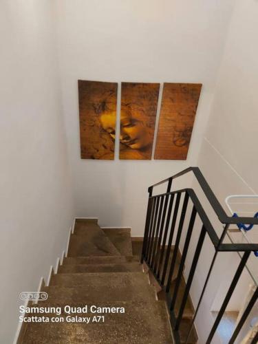 a staircase with two paintings on the wall and a stair case at Delizioso appartamento centro storico, Frosinone in Frosinone