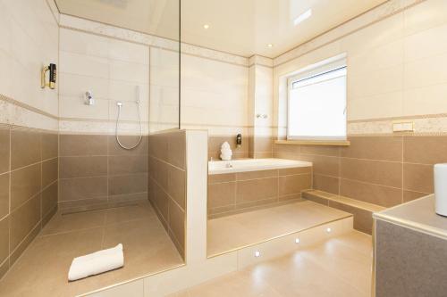 a large bathroom with a shower and a sink at Hotel-Restaurant Breitenbacher Hof in Hürth
