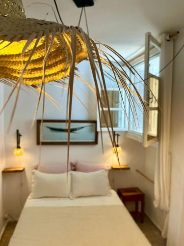 a bedroom with a bed with two pillows under a ceiling at Hôtel Emeraude Essaouira in Essaouira