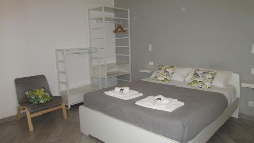 トラーパニにあるAl Vico Pescatoriの小さなベッドルーム(ベッド1台、椅子付)