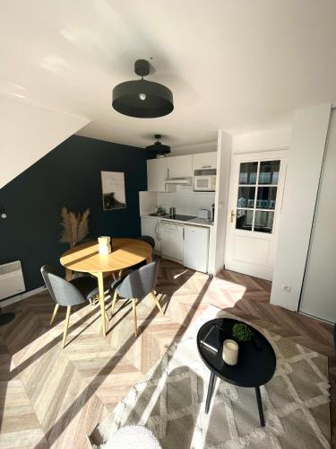 un salon avec une table et des chaises et une cuisine dans l'établissement Studio Stella plage terrasse, à Cucq