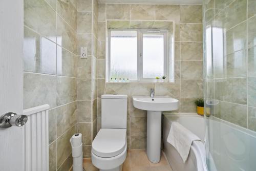 ein Badezimmer mit einem WC, einem Waschbecken und einer Badewanne in der Unterkunft Three Bedroom Home Near Central Milton Keynes by HP Accommodation with Free Parking, WiFi & Sky TV in Milton Keynes