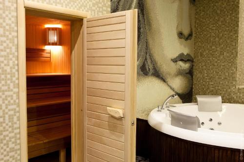 a bathroom with a sink and a bath tub at Kiroff Hotel in Kharkiv