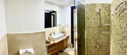 ein Bad mit einem Waschbecken, einem WC und einer Dusche in der Unterkunft Apartment Azzura Sahl Hasheesh with private garden in Hurghada