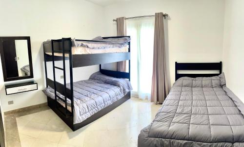 2 beliches num quarto com um espelho em Apartment Azzura Sahl Hasheesh with private garden em Hurghada