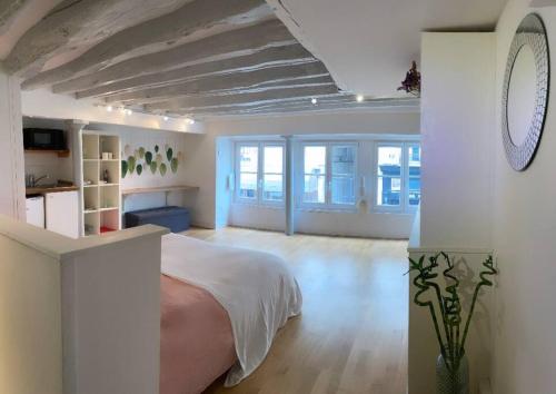 une chambre avec un lit dans une pièce blanche dans l'établissement Beau studio Gare de Lyon, à Paris