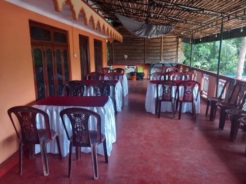 a row of tables and chairs in a restaurant at Thisha Hotel & Restaurant in Jaffna