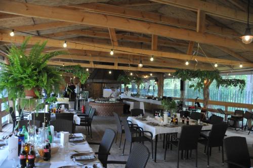 a dining room with tables and chairs in a restaurant at Ośrodek Wypoczynkowy Wielki Błękit in Łukęcin