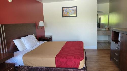 a hotel room with a bed and a kitchen at King's Inn Motel in Reading