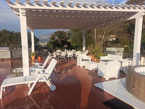 a group of white chairs and tables on a patio at La Terrazza Quisisana Sorrento Coast in Castellammare di Stabia