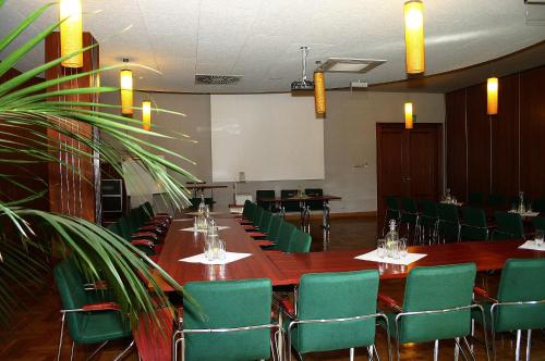 a conference room with a long table and green chairs at Ośrodek Wypoczynkowy Wielki Błękit in Łukęcin