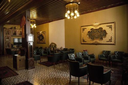 una sala de espera con un montón de sillas y un reloj en Tarihi Küçükağa Konağı en Aksehir