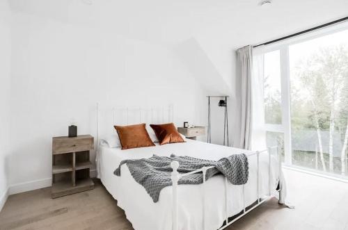 莫蘭高地的住宿－Allen Falls, chalet avec spa，白色的卧室设有白色的床和窗户。