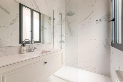 a white bathroom with a sink and a shower at ISG Apartments Cedaceros in Seville