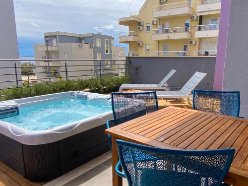 斯普利特的住宿－AstraMaris Znjan - Deluxe beach suite with hot tub，阳台的热水浴池,配有桌椅