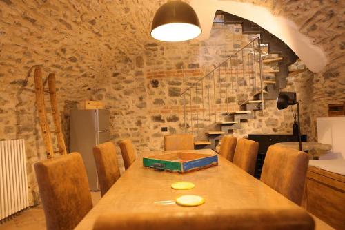 a dining room with a table with chairs and a staircase at Villa Maria in Bagnone