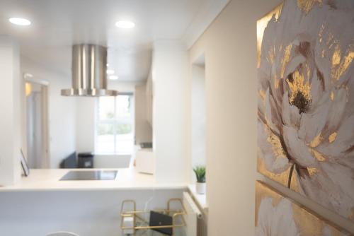 una cocina con una pintura de una flor en la pared en Homely 3 Bedroom House with Private Parking in Milton Keynes by HP Accommodation en Milton Keynes