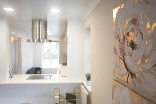 a kitchen with a painting of a flower on the wall at Homely 3 Bedroom House with Private Parking in Milton Keynes by HP Accommodation in Milton Keynes