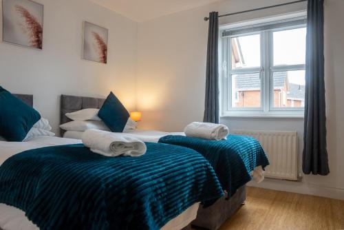 a bedroom with two beds and a window at Homely 3 Bedroom House with Private Parking in Milton Keynes by HP Accommodation in Milton Keynes