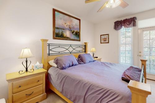 a bedroom with a large bed and a dresser with a lamp at Bear Trap Dunes - 58A October Glory Ave in Ocean View