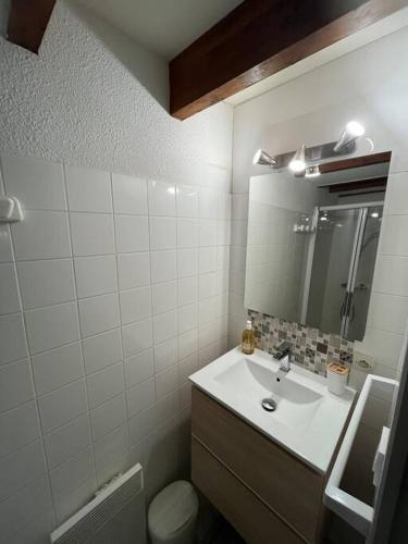 une salle de bain avec un lavabo et un miroir et des toilettes dans l'établissement Maison 400m plage, à Mimizan