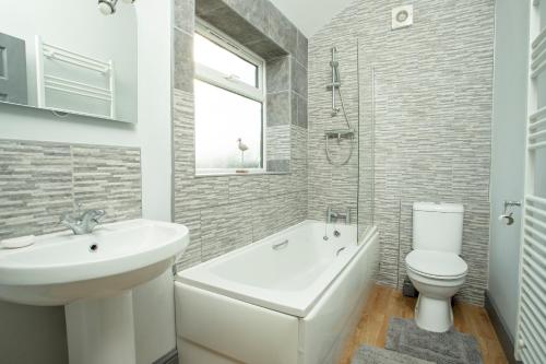 a white bathroom with a sink and a toilet at Willow Cottage a quaint holiday cottage in Wigtoft Boston Lincolnshire in Boston