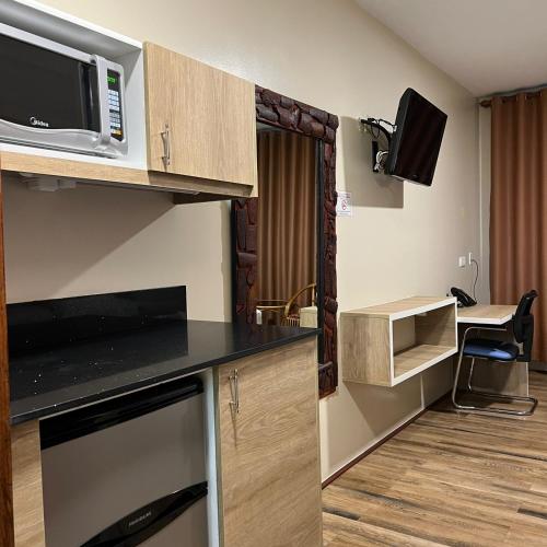 a small room with a kitchen with a microwave at Joah Inn Appartementen in Paramaribo