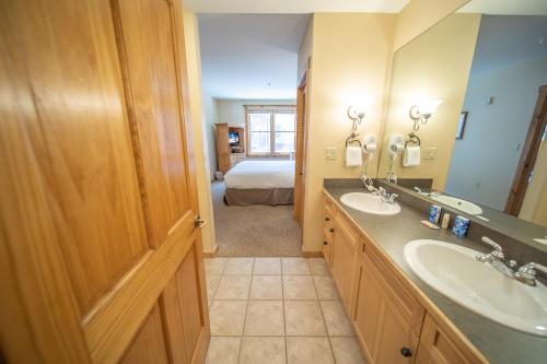a bathroom with two sinks and a bedroom at Buffalo Lodge 8327 in Keystone