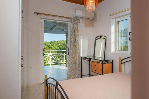 1 dormitorio con 1 cama y puerta a un balcón en Krystalia's house, en Psarou