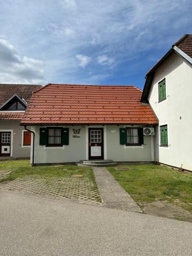 een wit huis met een rood dak bij Apartment Butterfly in Čatež ob Savi