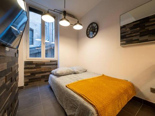 a bedroom with a bed and a clock on the wall at *Appartement climatisé au cœur du vieux port* in Marseille