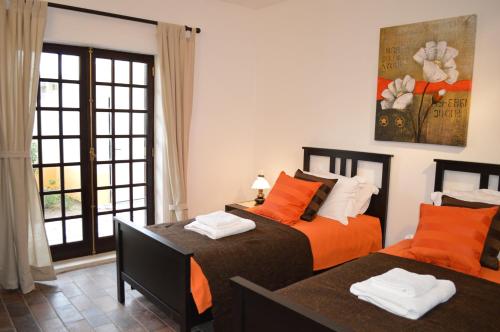 two beds in a room with a window at Casa Grande Holidays in São Martinho do Porto