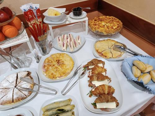 a table with many plates of food on it at Hotel La Vela in Lido di Camaiore