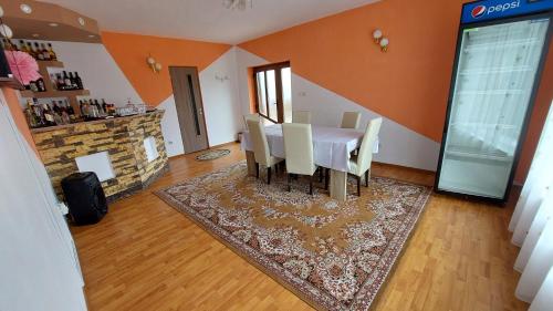 a dining room with a table and chairs and a fireplace at Vila Coman in Întorsura Buzăului
