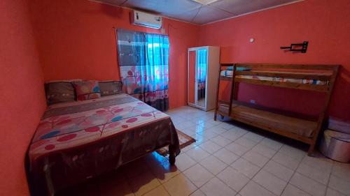 BelfastにあるCharming 1-Bedroom House in St Thomas Jamaicaの赤い壁のベッドルーム1室、ベッド1台、出入り口が備わります。