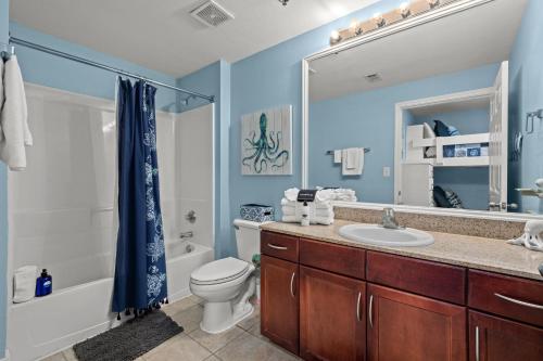 a bathroom with a sink and a toilet and a shower at White Sandy Beaches, Sunsets & Seashells at Laketown Wharf #402 by Nautical Properties in Panama City Beach