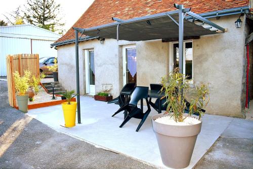 een patio met een tafel en stoelen onder een luifel bij Maison de charme in Ligueil