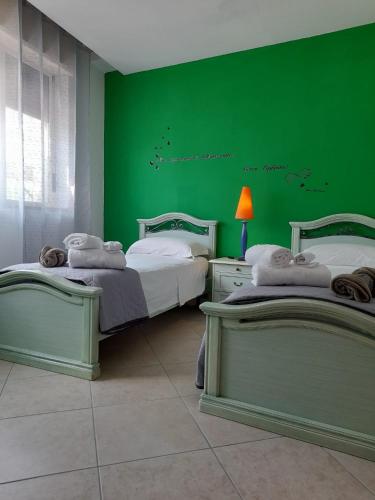 2 camas en una habitación con paredes verdes en Il Girasole, en Caserta