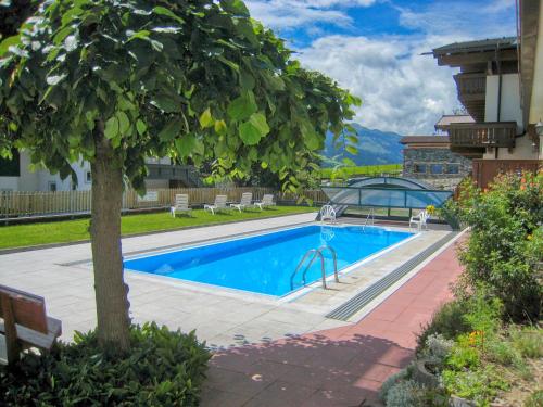 a swimming pool with a tree in a yard at Select Top 7 - by Alpen Apartments in Aufhausen