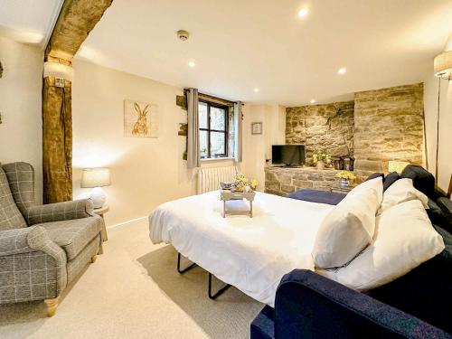 a bedroom with a large bed and a stone wall at Kite 1 - Uk6549 in Llanfihangel-Bryn-Pabuan