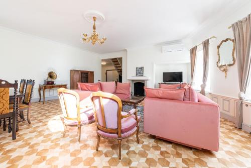 a living room with pink chairs and a table at Old Town - Demini Apartment in Tallinn