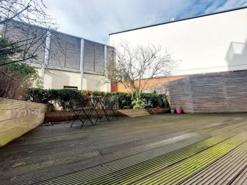 a patio with two benches in front of a building at City Apartment with Terrace in Leicester