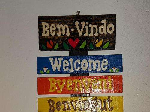 a sign that says ben vimo welcome and some books at Recanto Águas Claras in Soledade de Minas