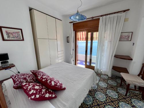 Un dormitorio con una cama con almohadas rojas. en Suite Capri, en Isquia