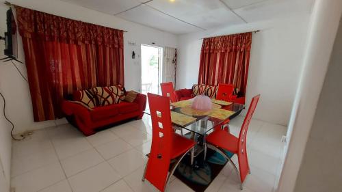 salon ze stołem i czerwonymi krzesłami w obiekcie Lovely 2 Bedroom House in St Thomas Jamaica w mieście Belfast