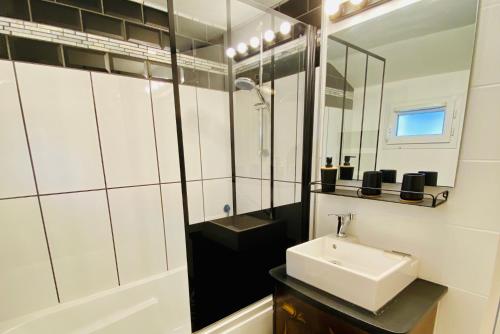 a white bathroom with a sink and a mirror at La Maison des Plantes, charmante, atypique et cosy pour 4 personnes avec parking et jardin in Rouen