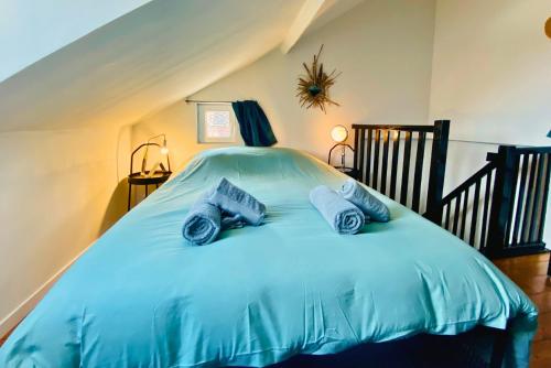 a bedroom with a bed with blue sheets and pillows at La Maison des Plantes, charmante, atypique et cosy pour 4 personnes avec parking et jardin in Rouen