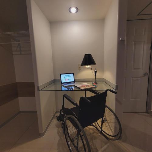 a bike parked next to a glass desk with a laptop at Hotel CH in Guadalupe