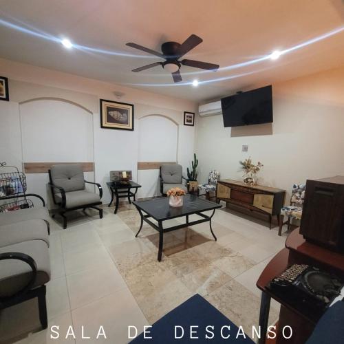 a living room with a couch and a ceiling fan at Hotel CH in Guadalupe