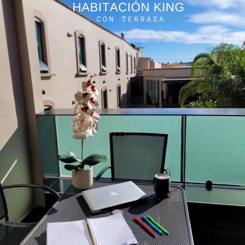 an apartment balcony with a table with a laptop on it at Hotel CH in Guadalupe